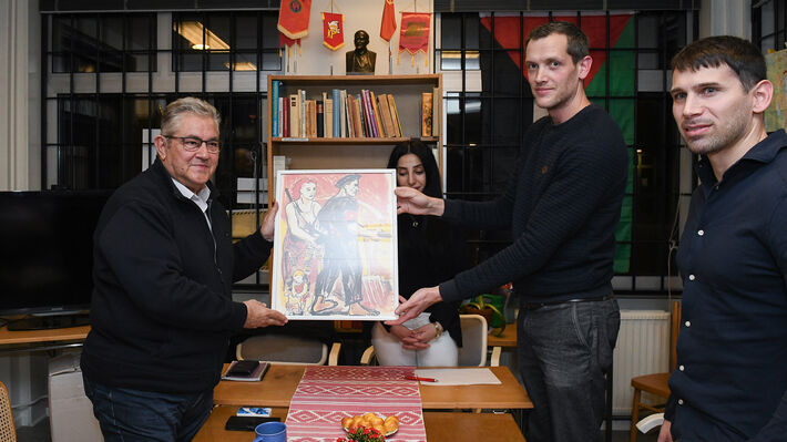 De svenska kommunisternas ordförande, Andreas Sörensen, överräcker en gåva till Dimitris Koutsoumbas.